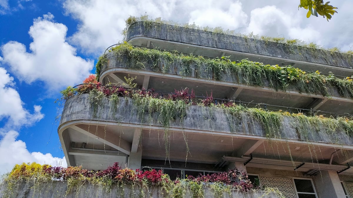 Yogyakarta, Indonesia - February, 2026: a modern multi-level building designed with lush green terraces that cascade gracefully along its curved concrete structure